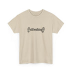 Beige t-shirt with 'still walking' text and footprints on a white background