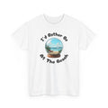 T shirt with beach-themed snow globe featuring a miniature sandy shoreline with a red lounge chair, tropical plants, blue ocean waves, and a bright sky, evoking a relaxing coastal vacation scene and the phrase 'I'd rather be at the beach'.